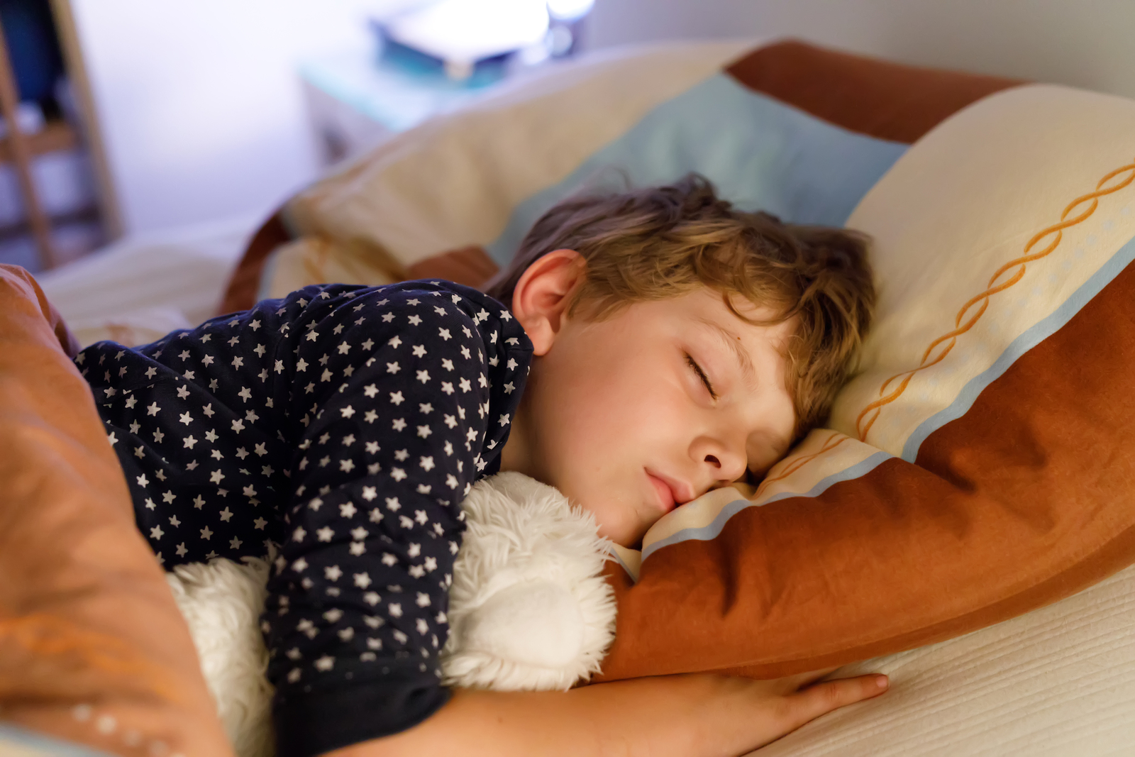 Little Preschool Kid Boy Sleeping In Bed With Colorful Lamp Sch