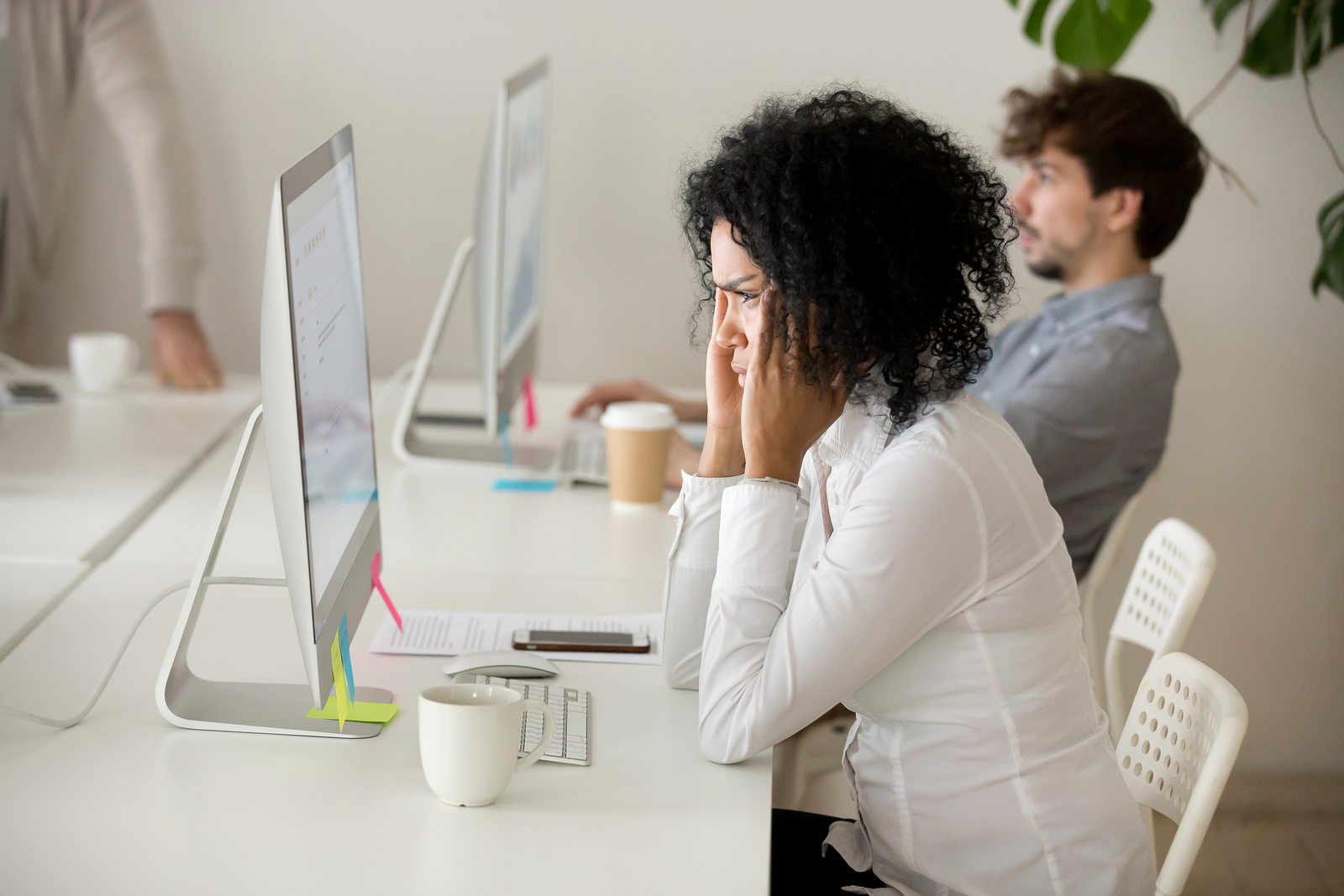 Stressed young african american businesswoman suffering from headache migraine touching temples at workplace frustrated black woman employee tired from computer work can not concentrate or focus